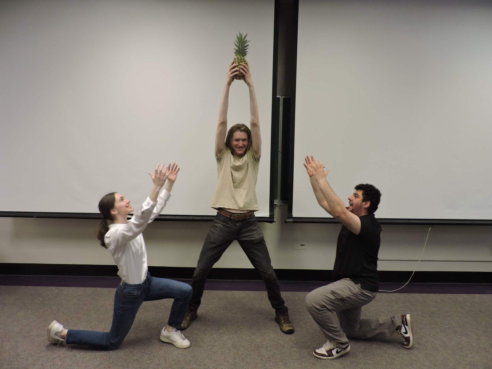 Alpha Phi Omega members raising a pineapple during Even's Big/Little ceremony