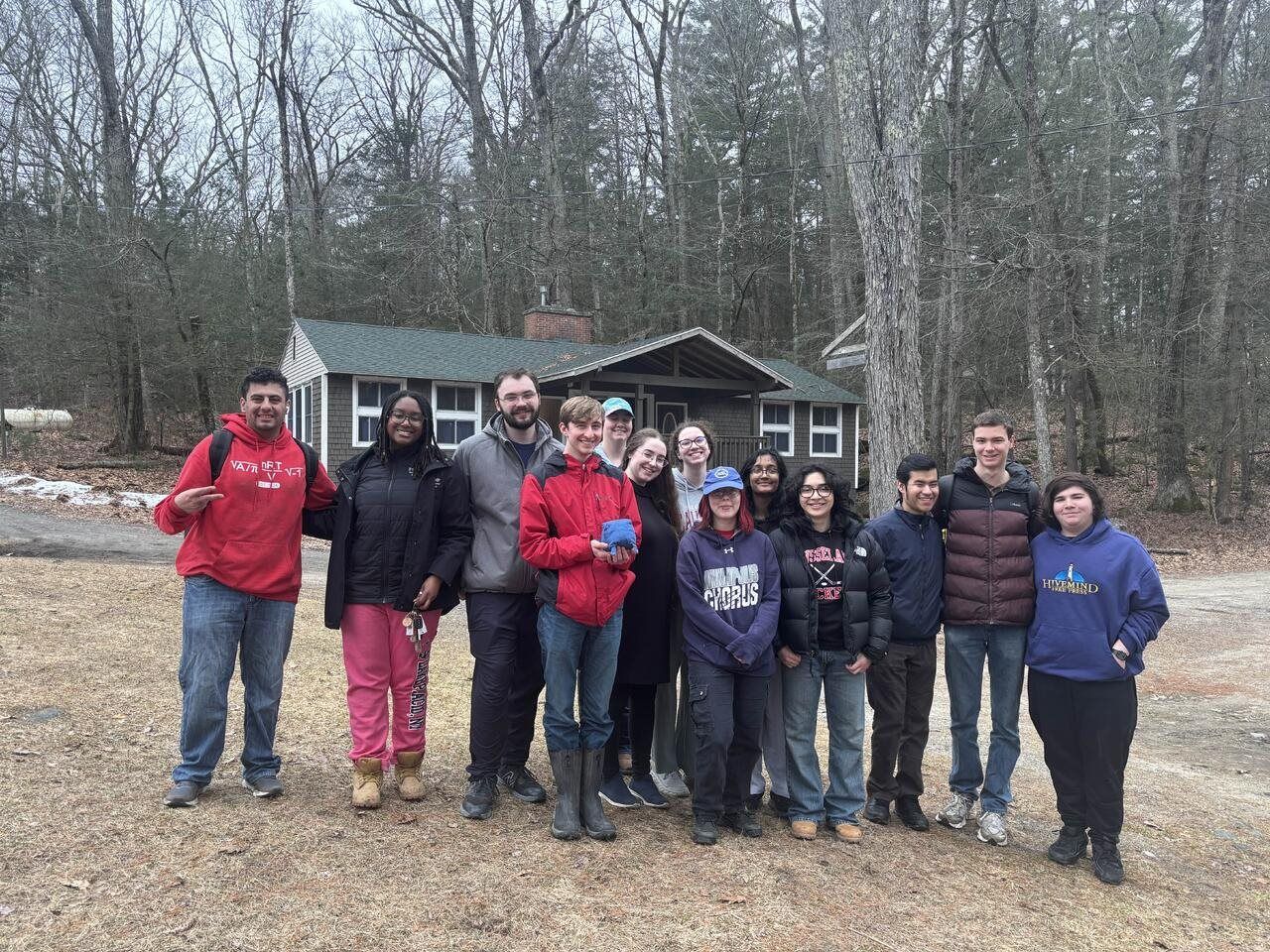 Group photo of Alpha Phi Omega members in front of a cabin at Camp Jewell YMCA