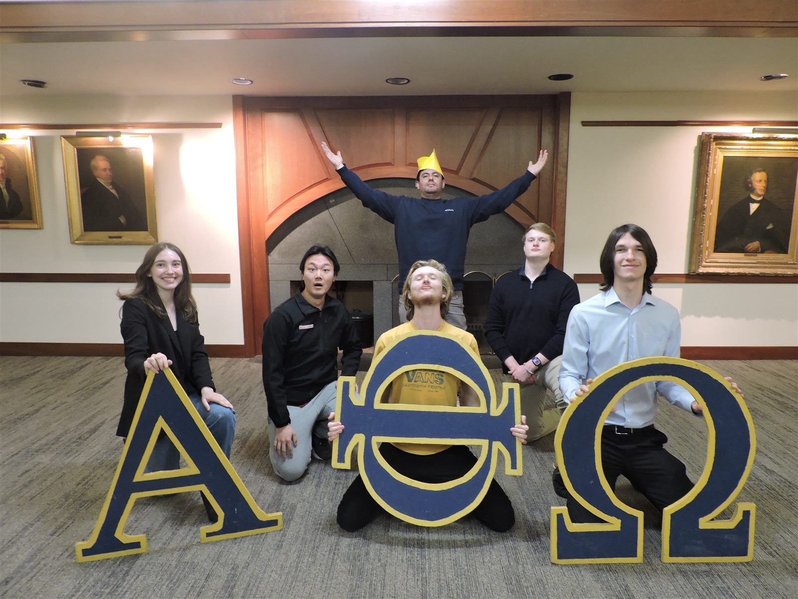 Armaan with his E Tree family in Alpha Phi Omega, posing with wooden Greek letters spelling ΑΘΩ