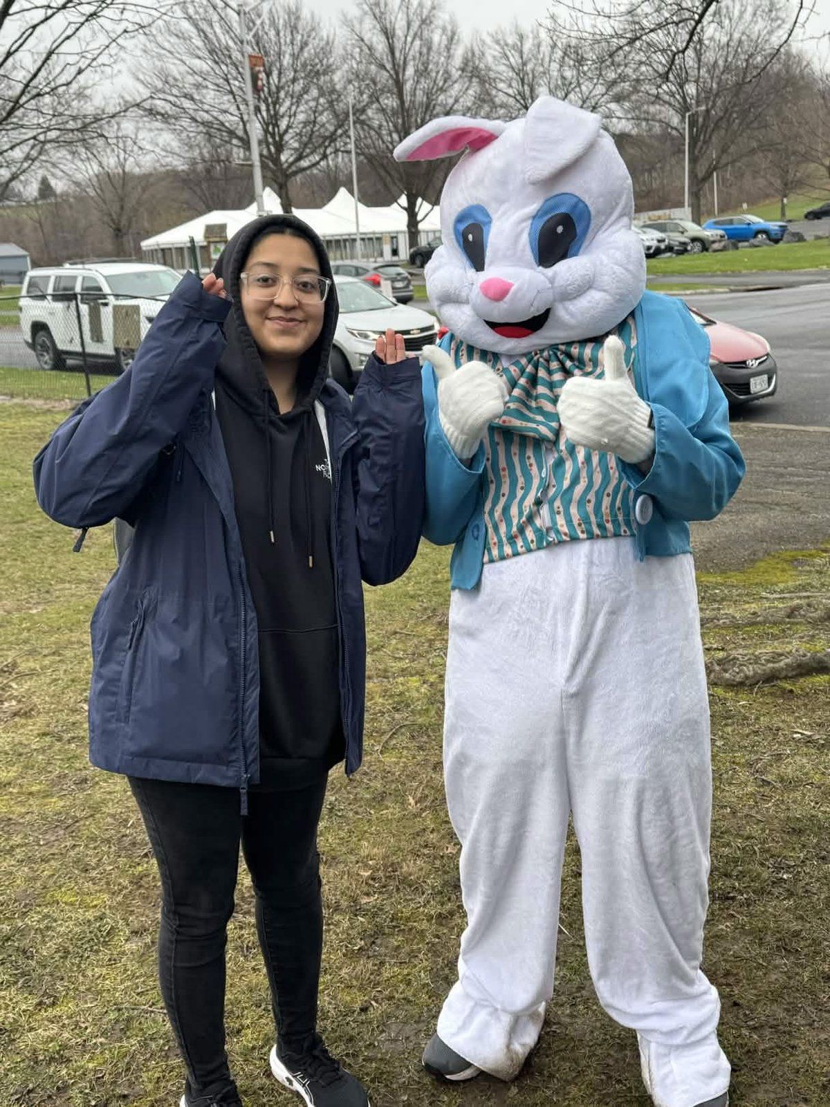 A youth group member posing with the Easter Bunny mascot at the Youth Service Day Easter celebration